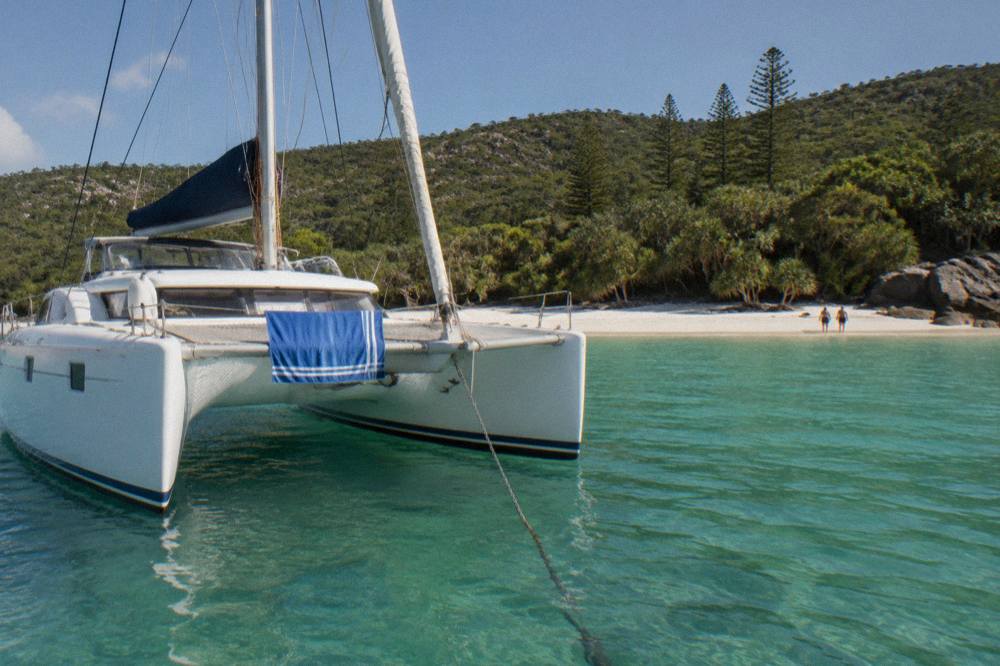 Sailing catamaran moored near a Whitsunday island beach